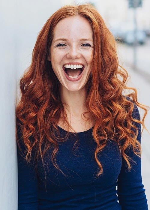 Woman with red hair smiling wide