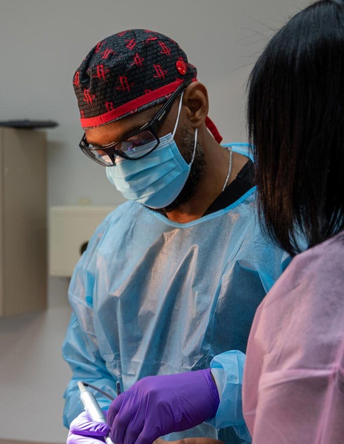 Dr. Johnson wearing a mask, performing oral surgery