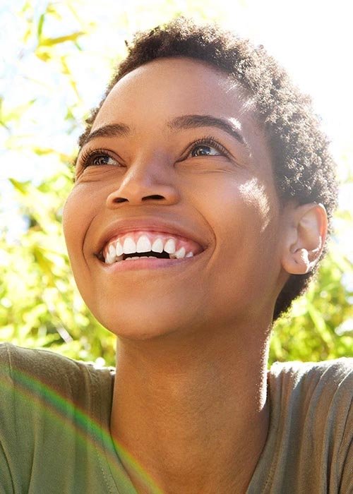 Close-up portrait of smiling woman in sunshine